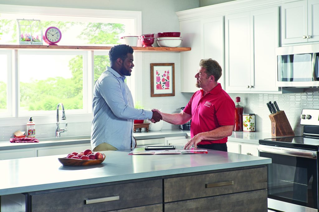 Bryant HVAC representative shaking hands with homeowner in kitchen