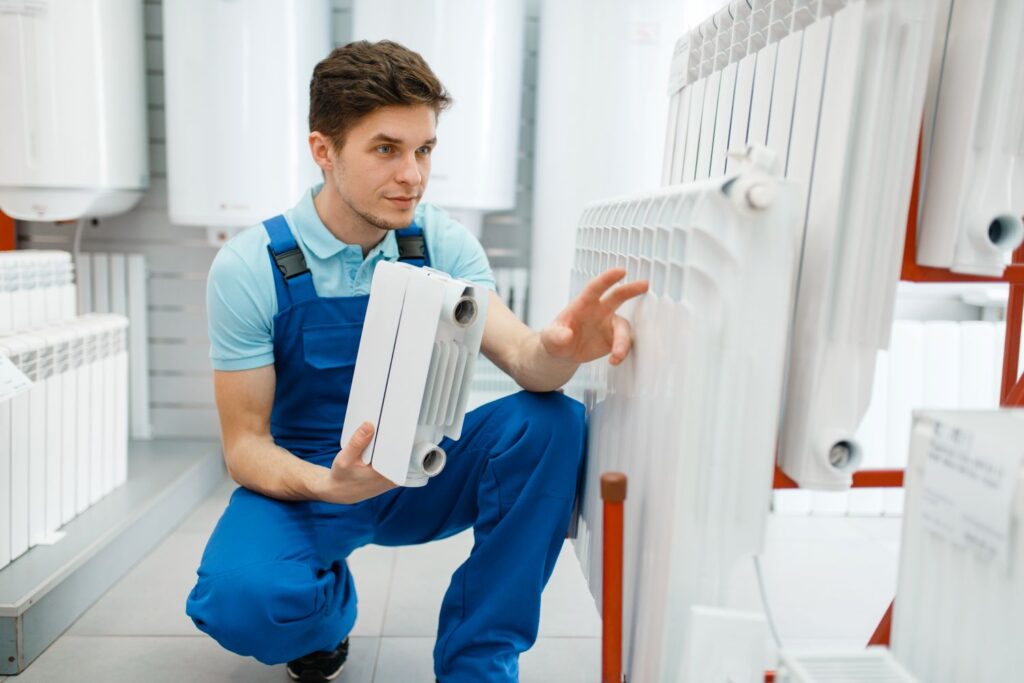 HVAC technician examining a two-stage furnace model in a showroom, highlighting options for heating upgrades.
