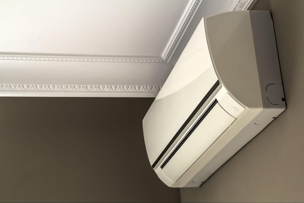Ductless heat pump indoor unit mounted on wall near ceiling in Macomb MI home