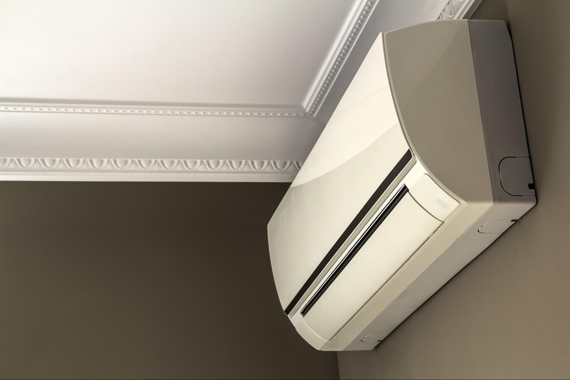 Ductless heat pump indoor unit mounted on wall near ceiling in Macomb MI home