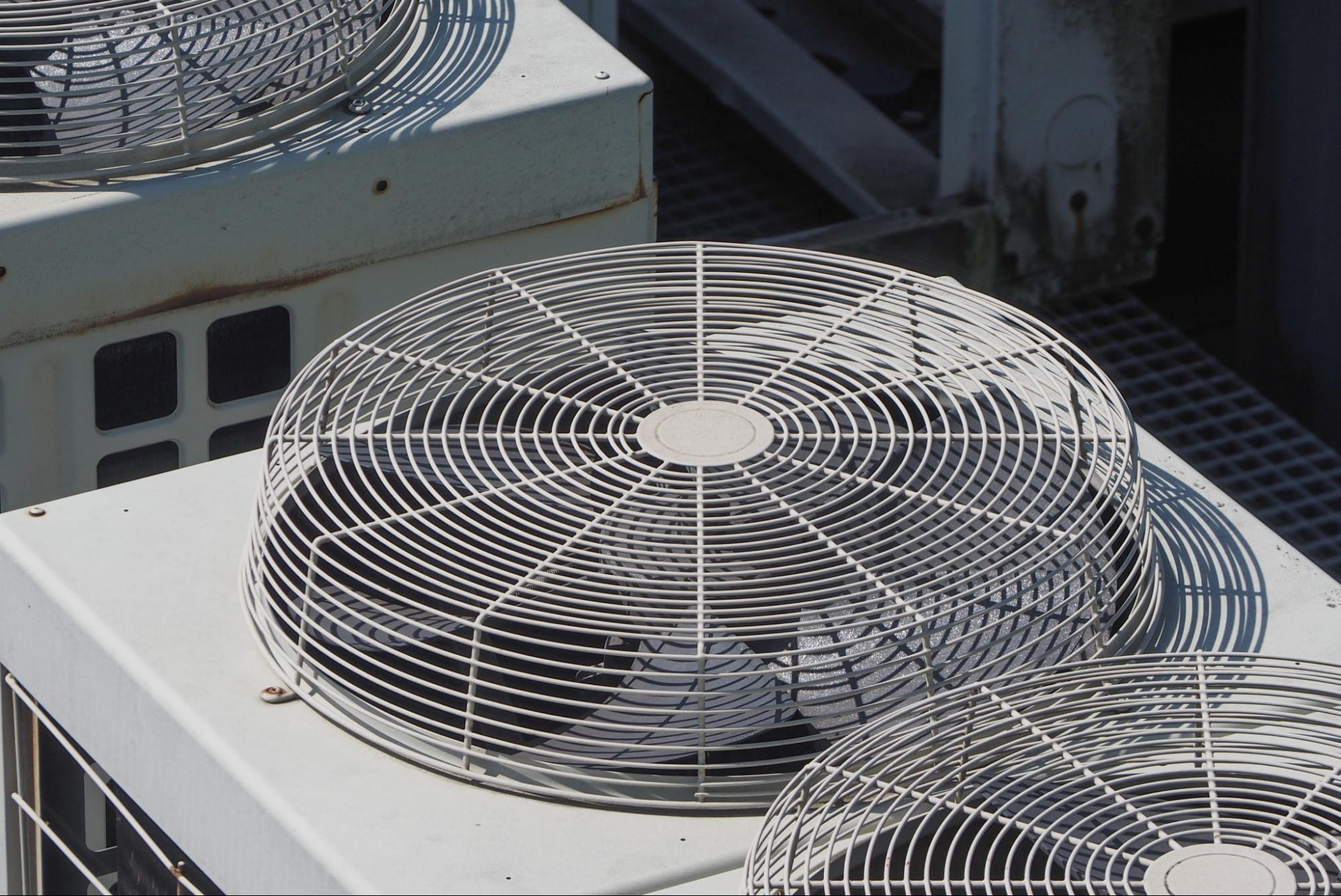 Rooftop air conditioning condenser fans managing cooling performance during Lake St. Clair's humid summer months in St. Clair County